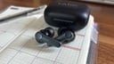 black earfun air pro 4 earbuds and case on top of open planner