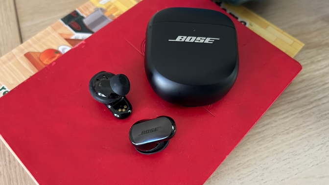 bose earbuds on red notebook